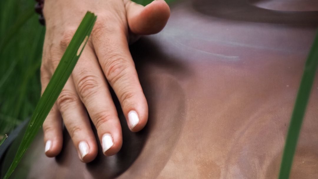 Person playing handpan in a peaceful setting